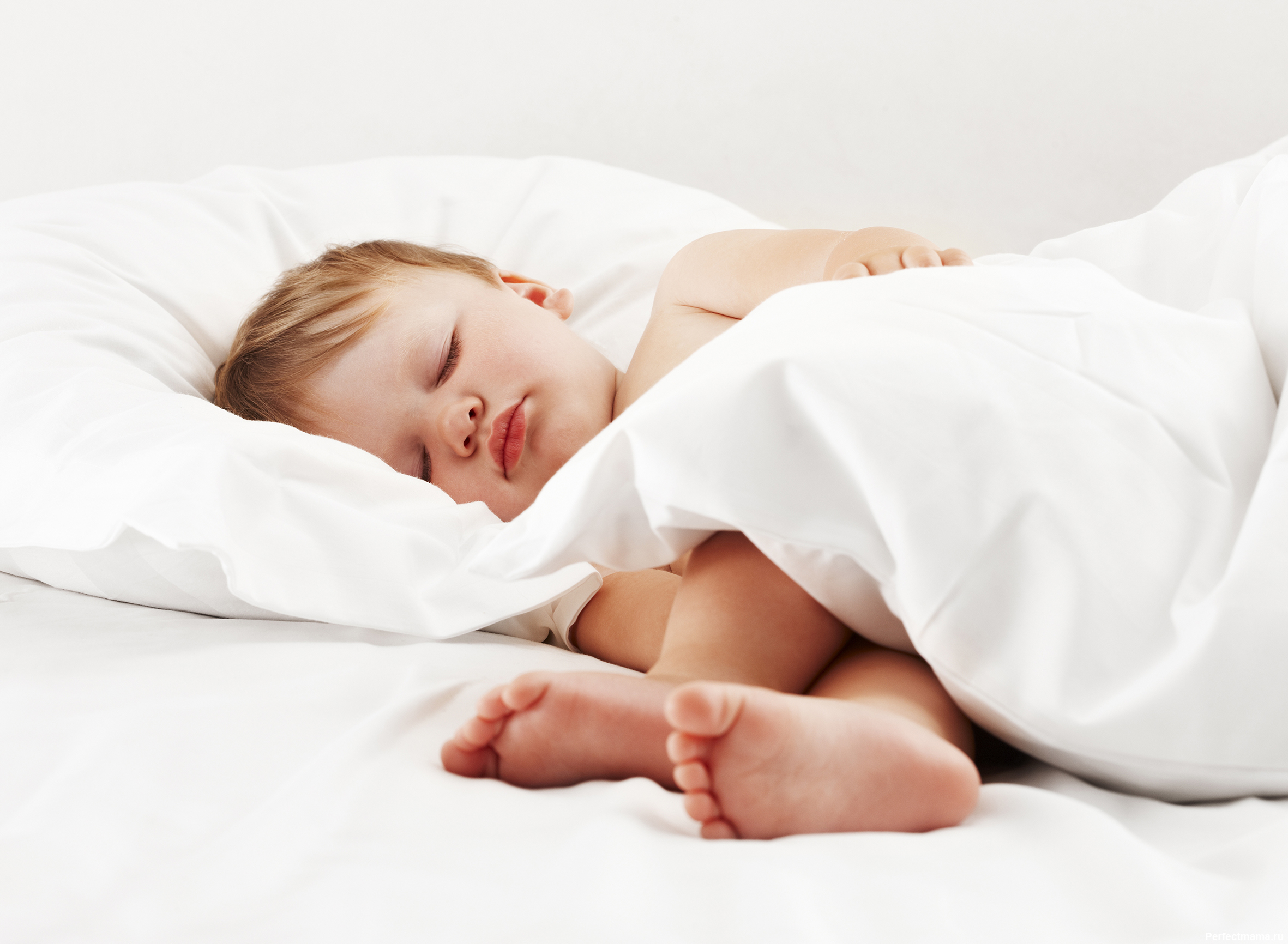 Baby lying on white sheet